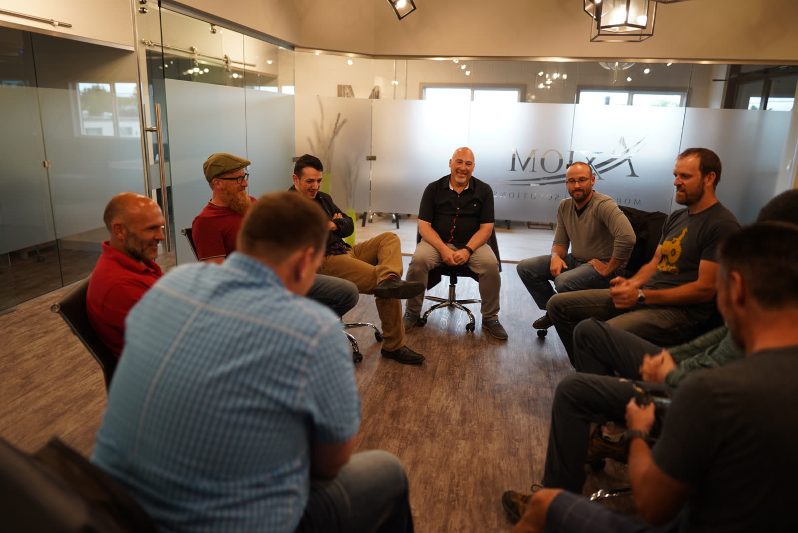 Men sitting together in a circle of chairs at a Connect'd Men gathering